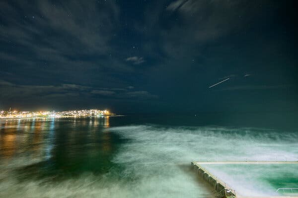 A meteor in the sky with a blurry foreground from a long exposure.