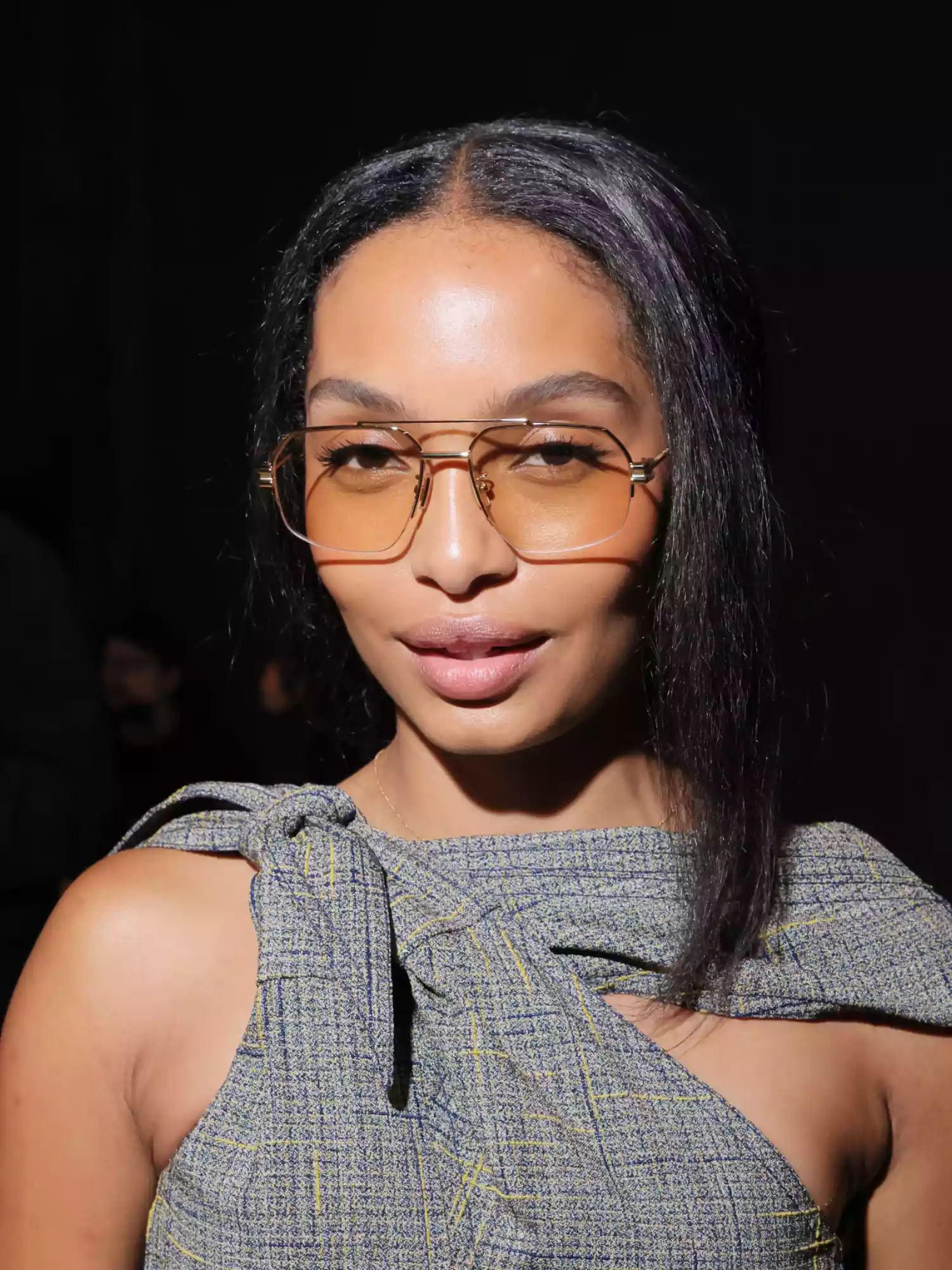 Yara Shahidi wearing sunglasses with yellow/orange colored lenses