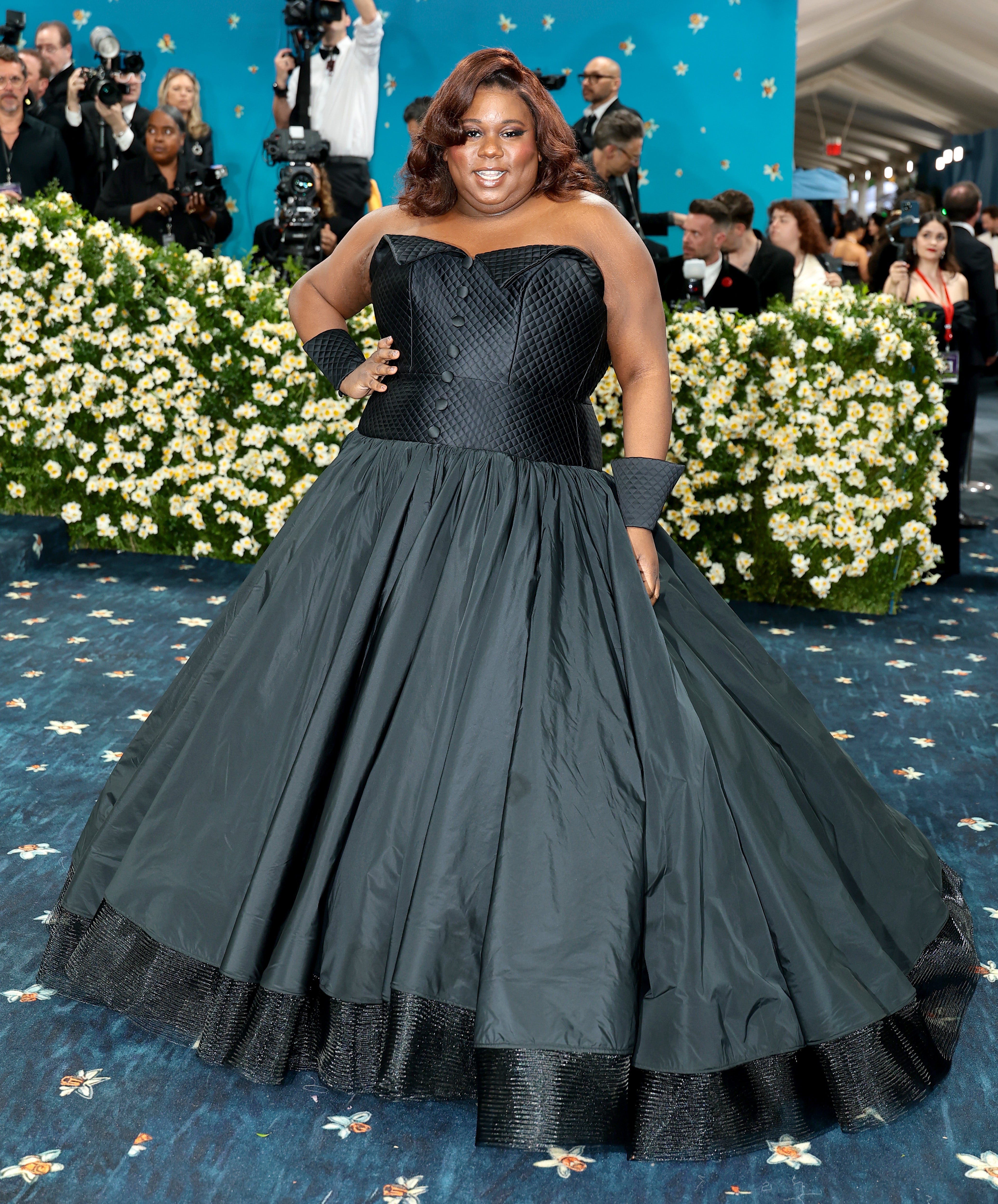 Tony winner Alex Newell wore a black gown with a pleated skirt and buttons on the top