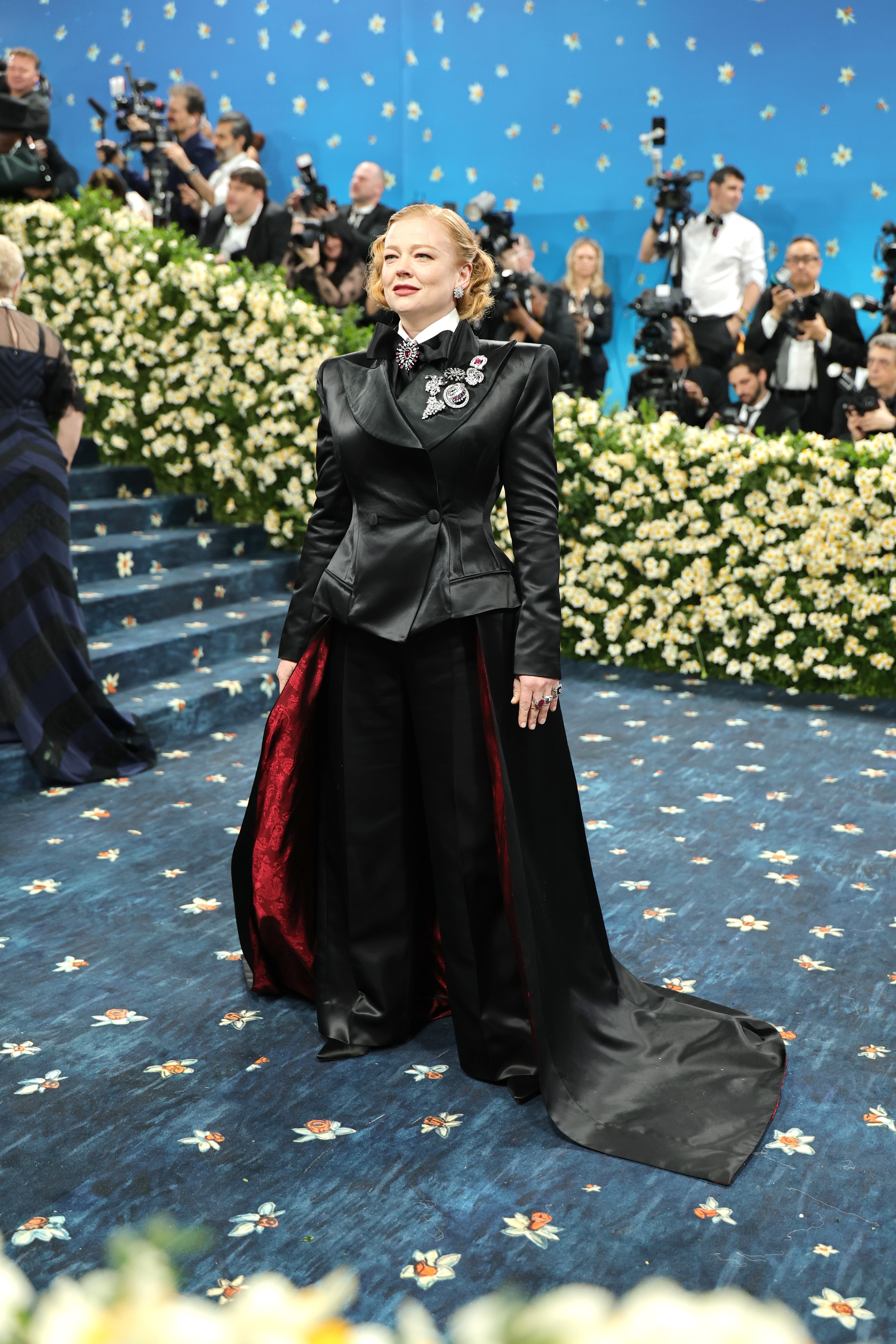 Sarah Snook wore a satin black jacket with a matching bowtie. Her jacket included a floor-length train that was red on the inside
