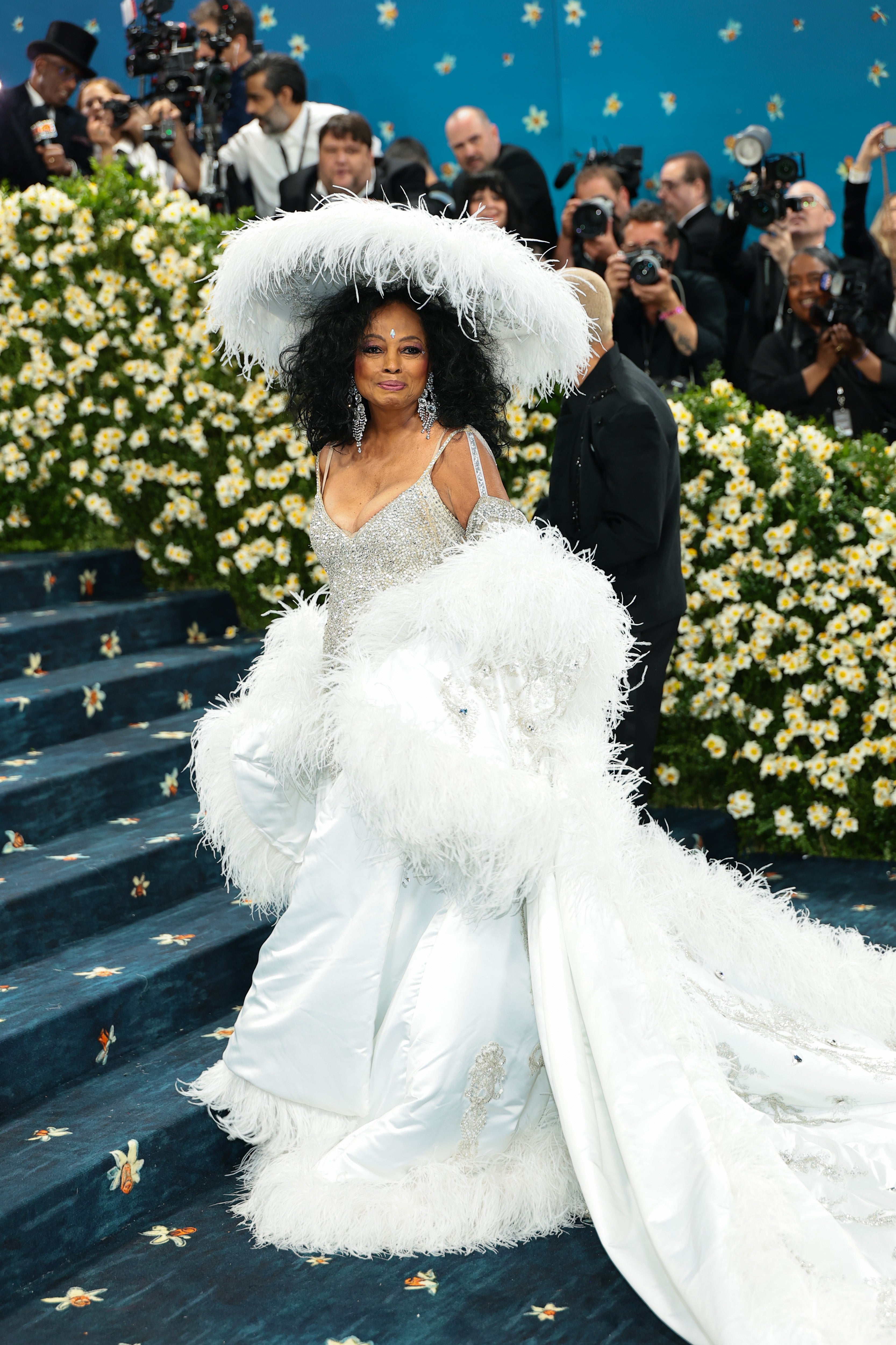 Diana Ross stunned in a silver dress with a satin white feather skirt, paired with a matching feather train