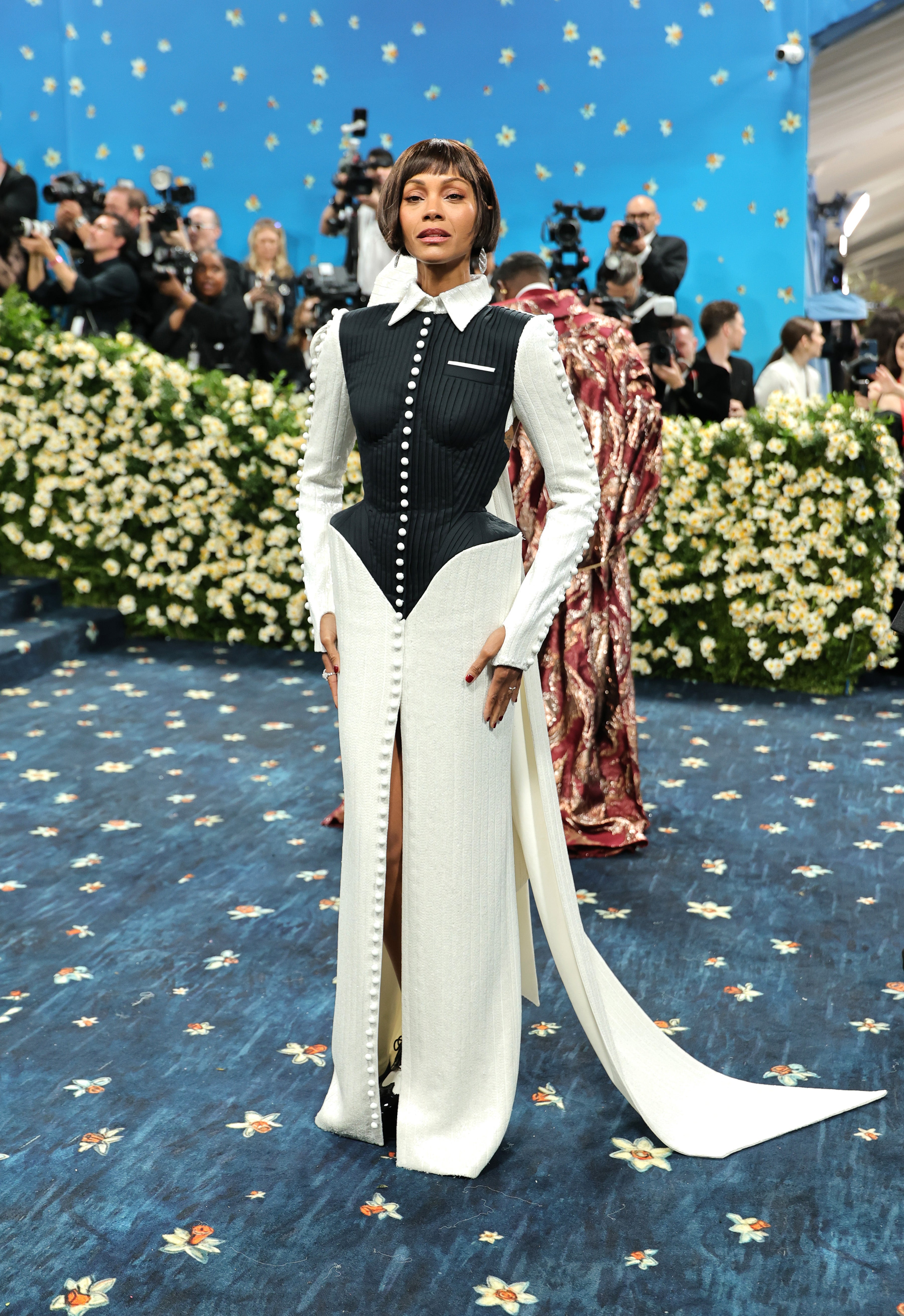 Zoe Saldaña wore a white dress with a slit and black vest top by Thom Browne