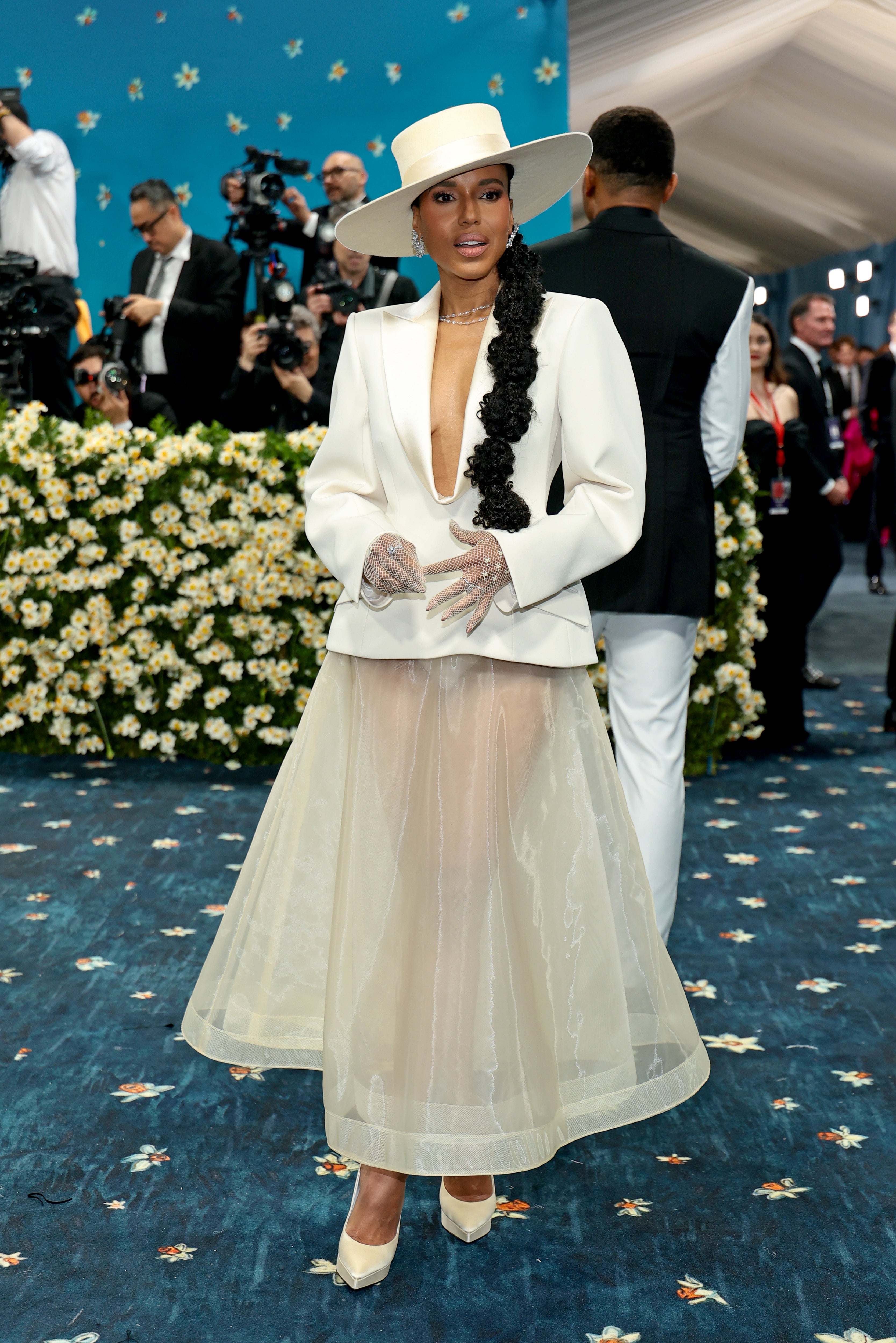 Kerry Washington wore a white, unbuttoned jacket and matching sheer skirt. She posed in a beige top hat, white heels, a sheer skirt, and fishnet gloves