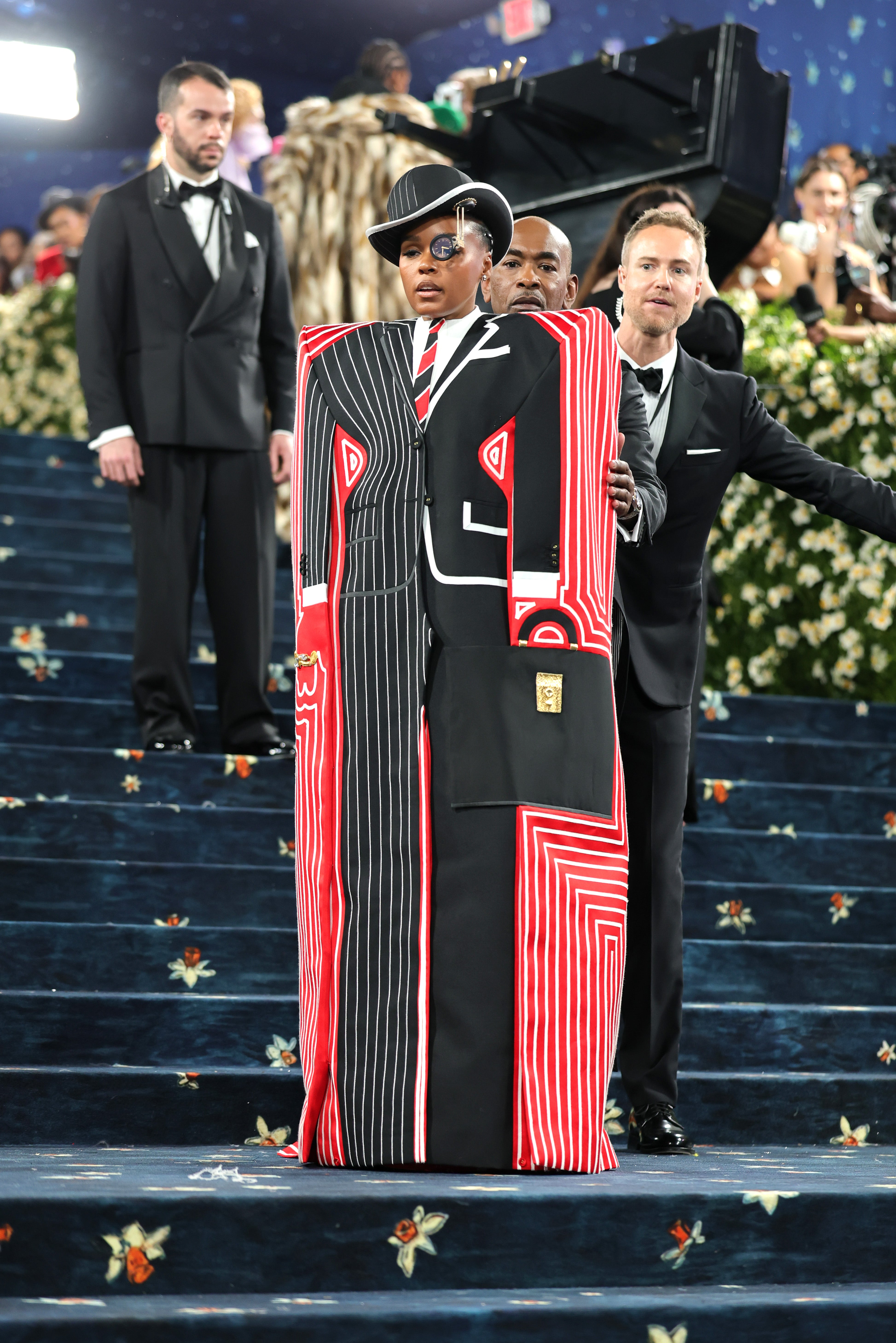 Janelle Monáe arrived at the Met Gala in a square cover-up, which included a picture of a suit and tie. Half the suit was striped while the other half was black