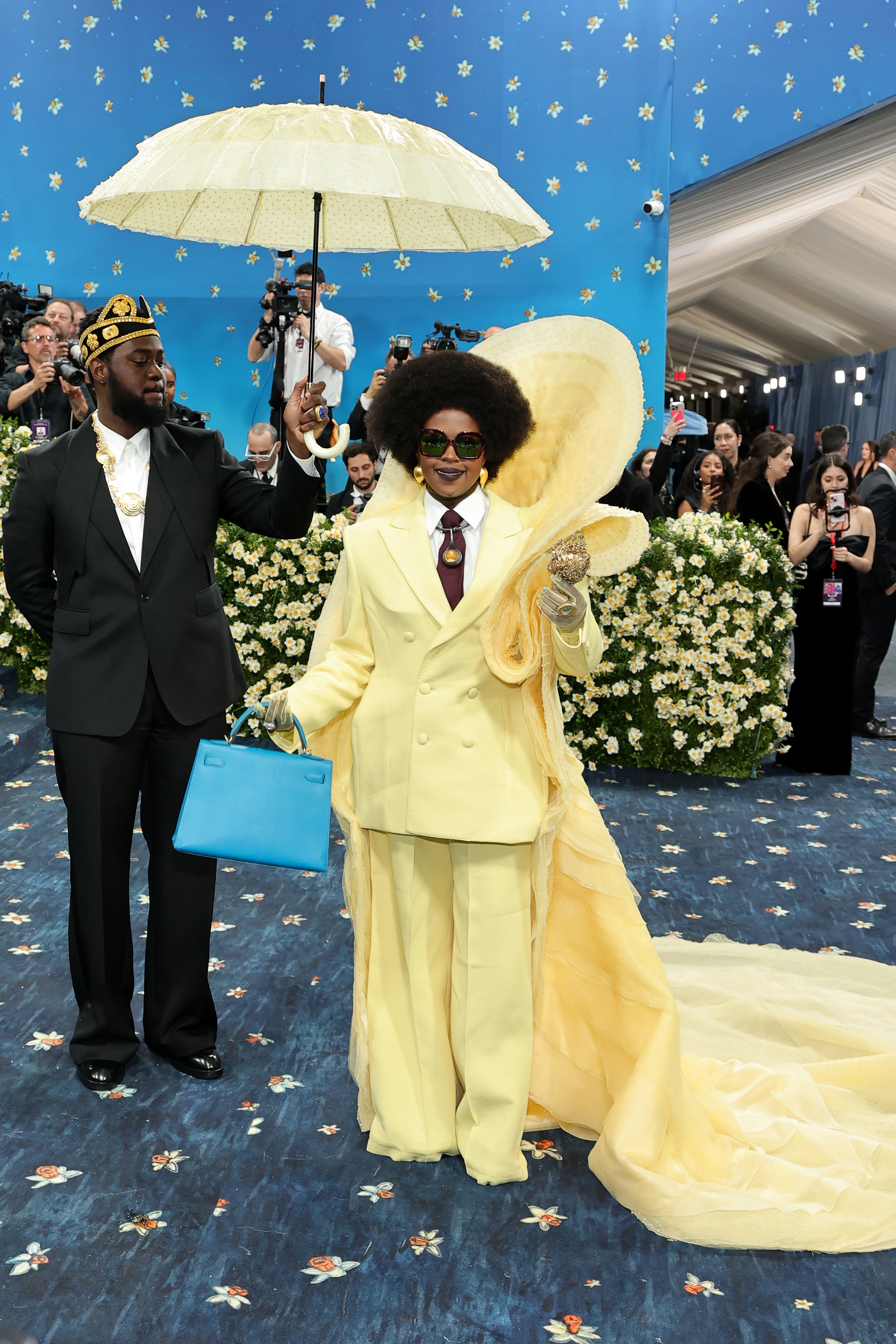 Hill was accompanied by a Met Gala worker, who was holding a matching yellow umbrella over her head